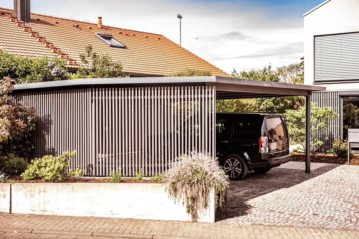 Moderner Carport aus Stahl mit Lamellen-Sichtschutz