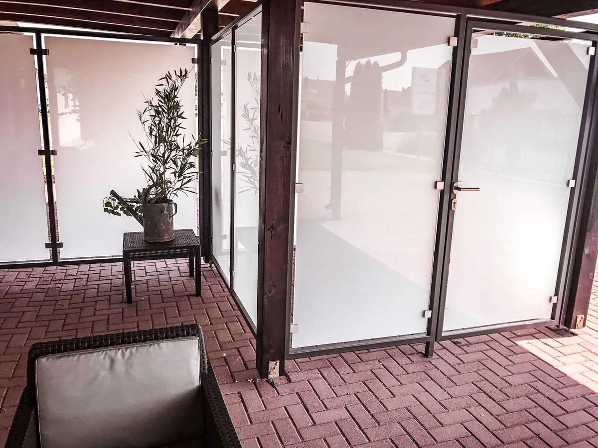 Windschutz aus Milchglas an der Terrasse mit Stahlrahmen