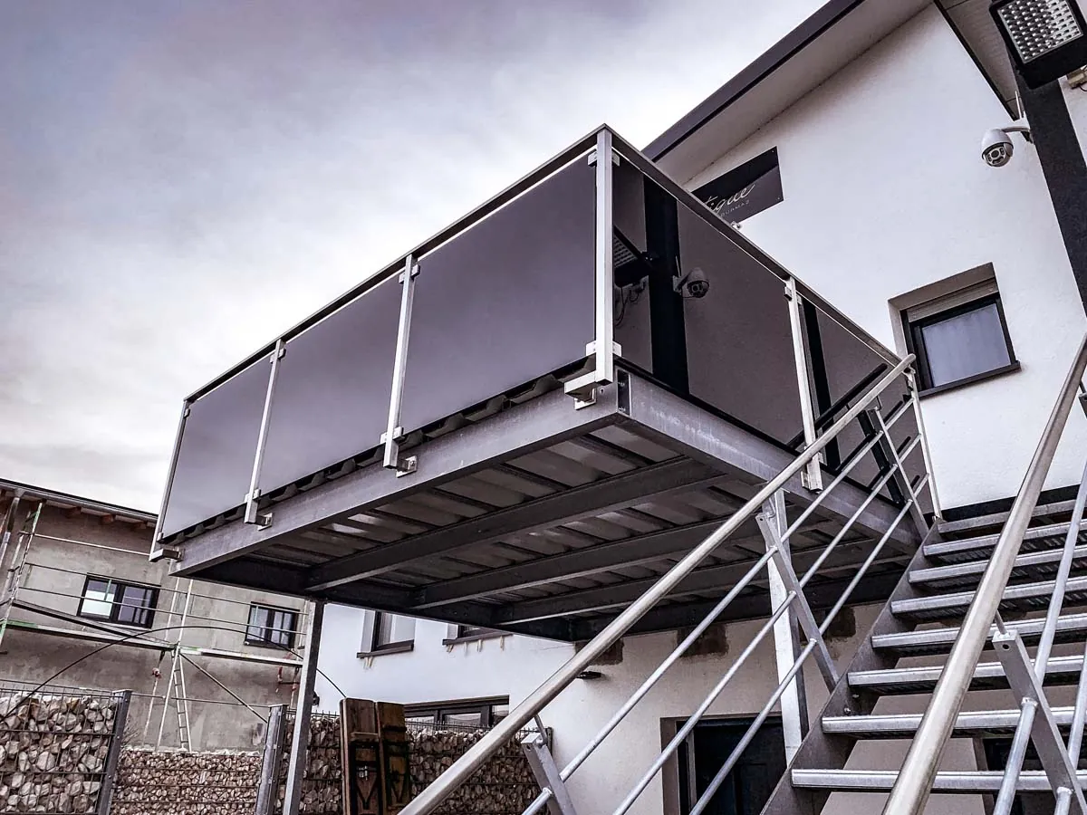 Balkonanbau mit Stahlkonstruktion, Geländer mit Glasfüllung und Außentreppe