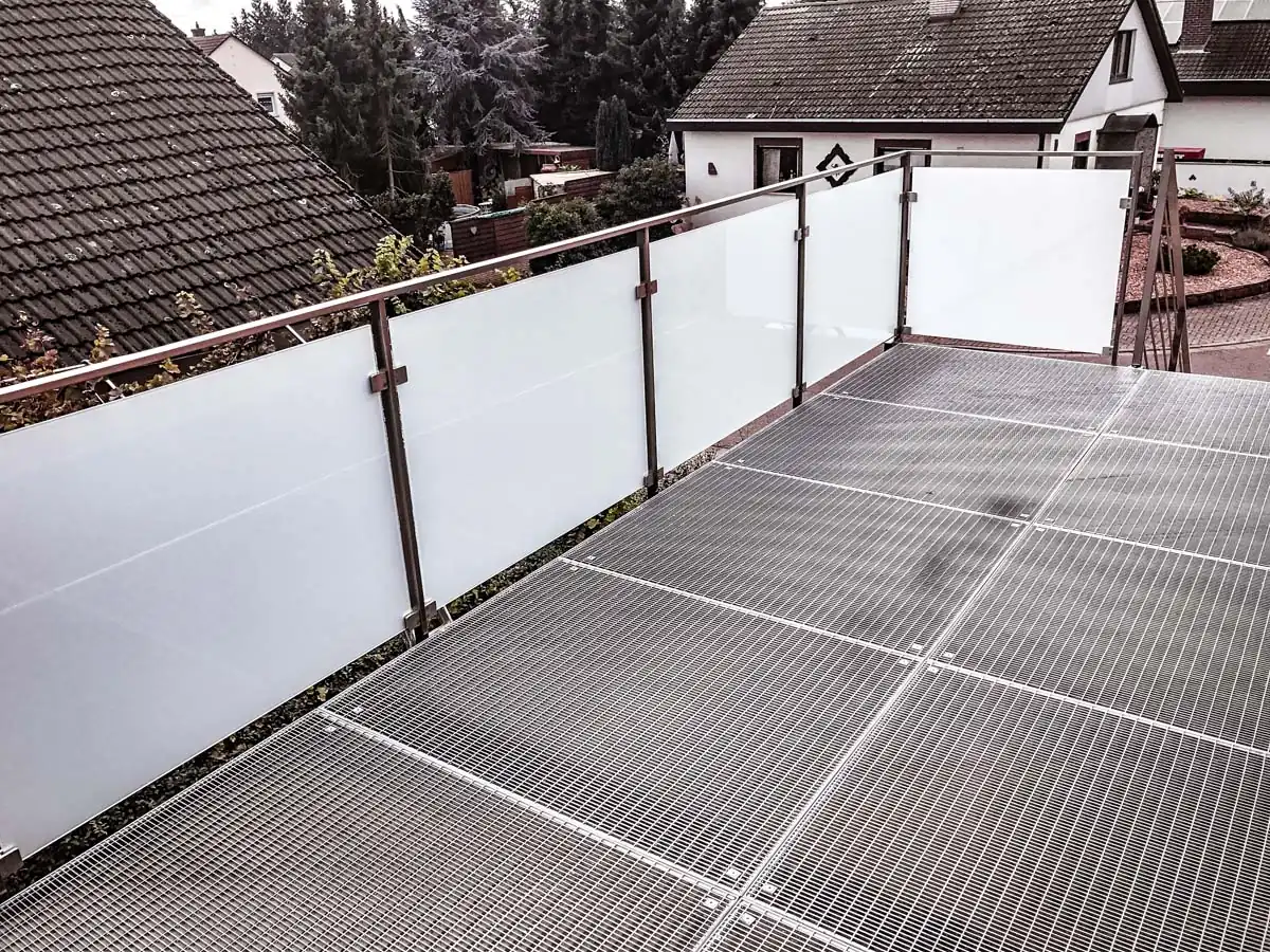 Balkongeländer aus Edelstahl mit Milchglas auf Gitterrostboden