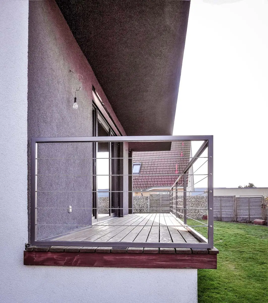 Modernes Balkongeländer aus Stahl mit Seilfüllung an Holzterrasse