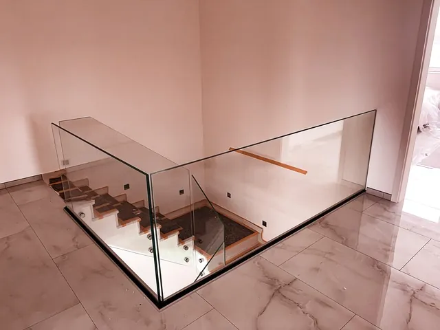 Rahmenloses Glasgeländer an Galerie und Treppenabgang innen