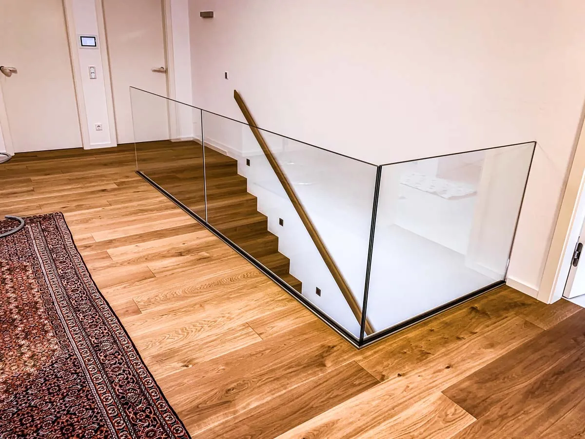 Rahmenloses Glasgeländer am Treppenabgang mit Holzboden innen