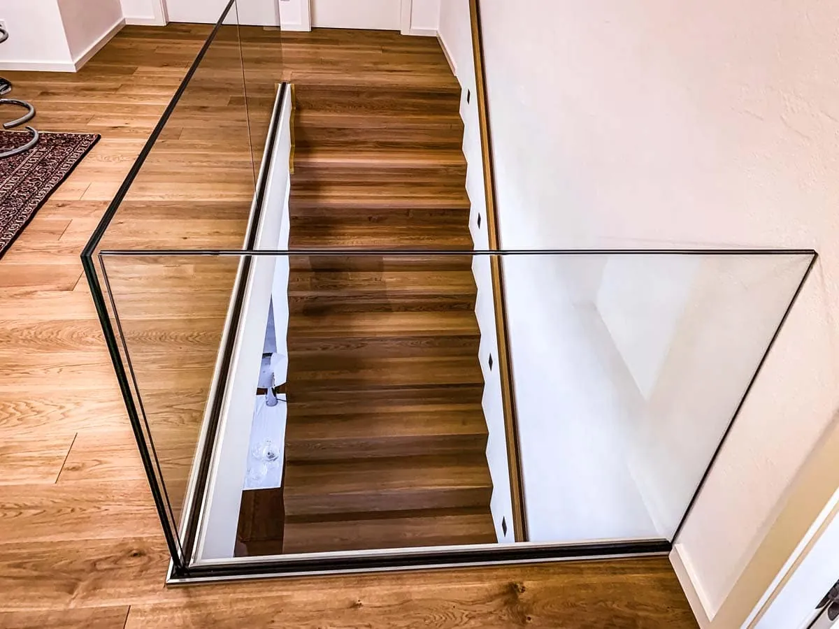 Rahmenloses Glasgeländer am Treppenabgang mit Holzboden innen, weitere Ansicht