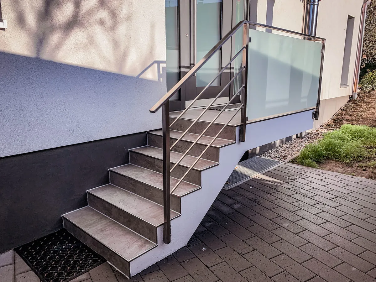 Treppengeländer aus Edelstahl mit Horizontalstäben und Glasfüllung am Eingang