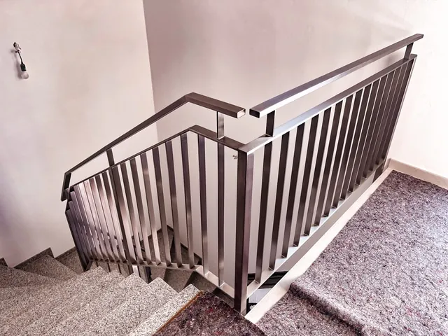 Treppengeländer aus Edelstahl mit Stabfüllung im Treppenhaus am Podest