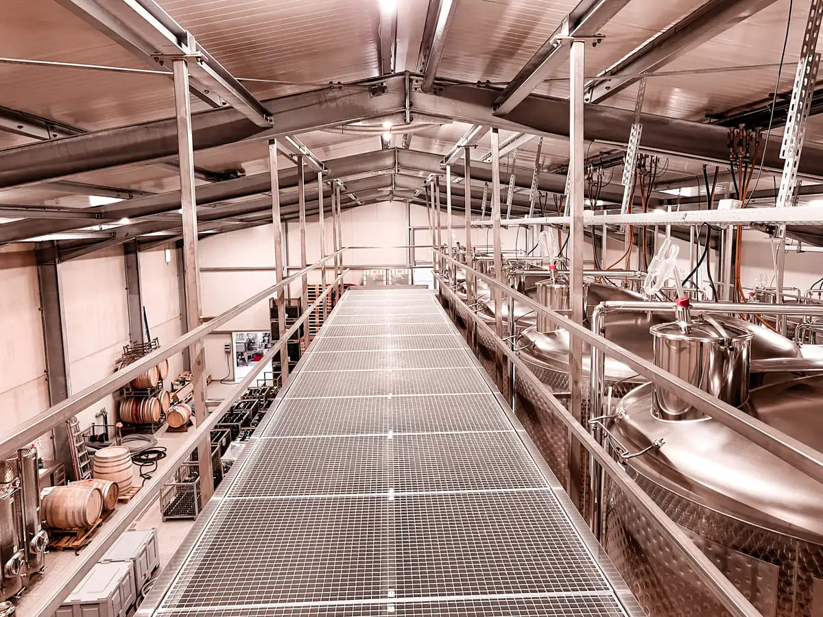 Stahlbühne mit Gitterrost im Weinkeller für Weintanks