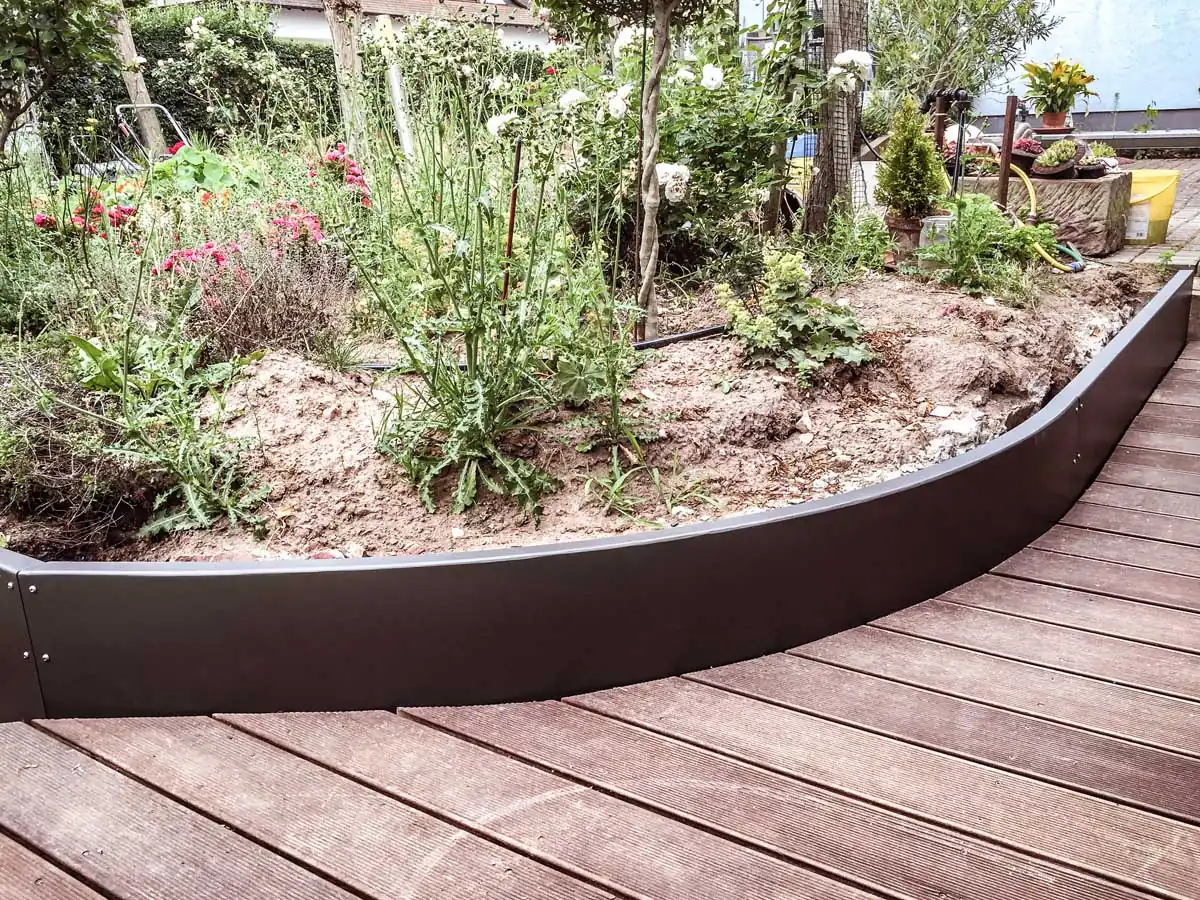 Geschwungene Beeteinfassung aus Stahl an der Terrasse in Anthrazit