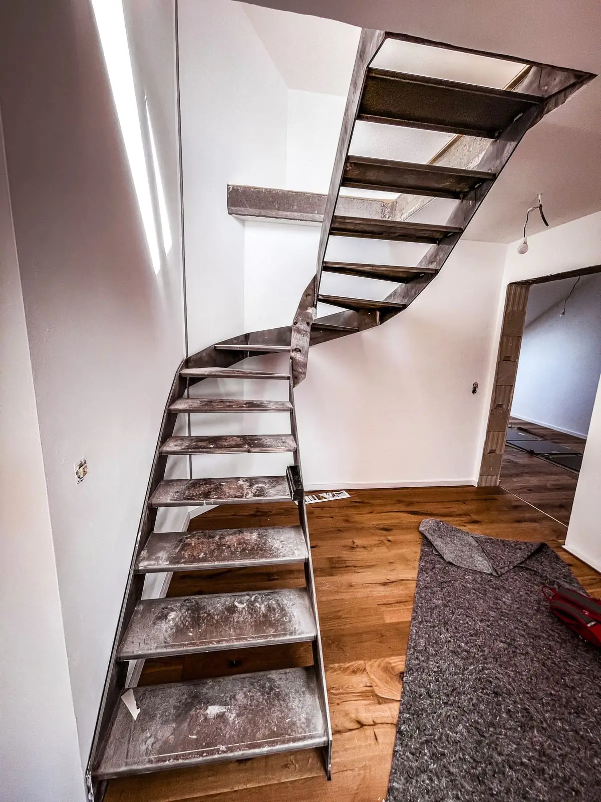 Geschwungene freitragende Innentreppe aus Stahl im Rohbau