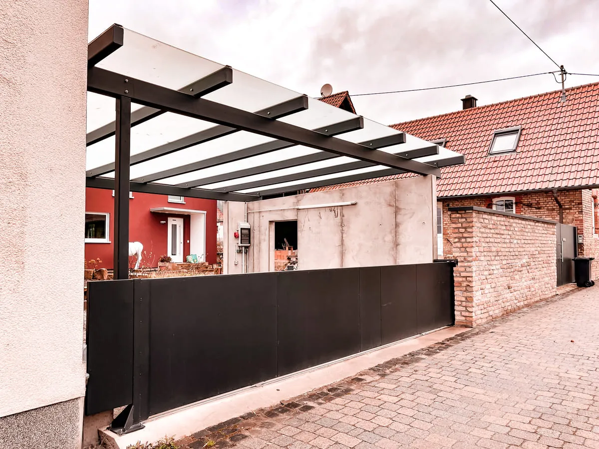 Terrassenüberdachung mit Glasdach und Sichtschutzpaneelen