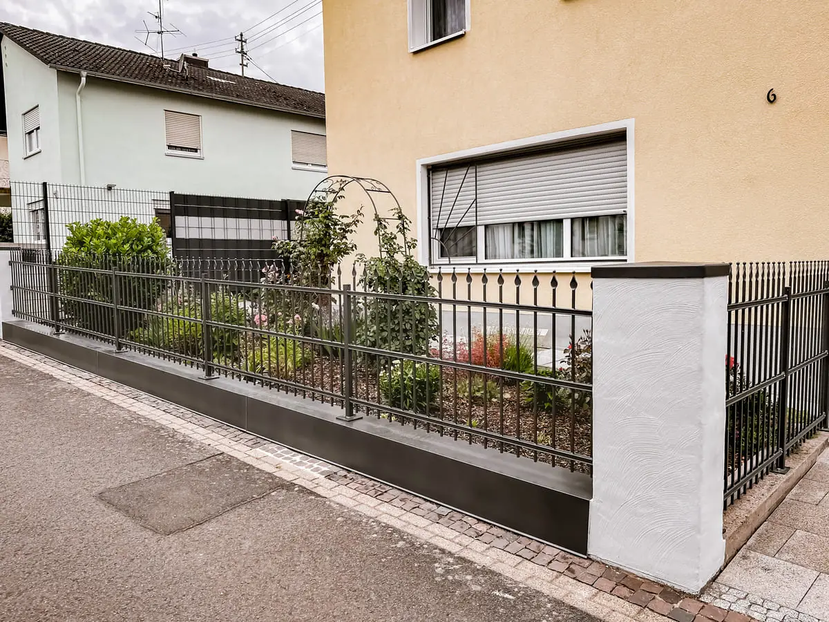 Klassischer Schmiedezaun mit Zierspitzen im Vorgarten